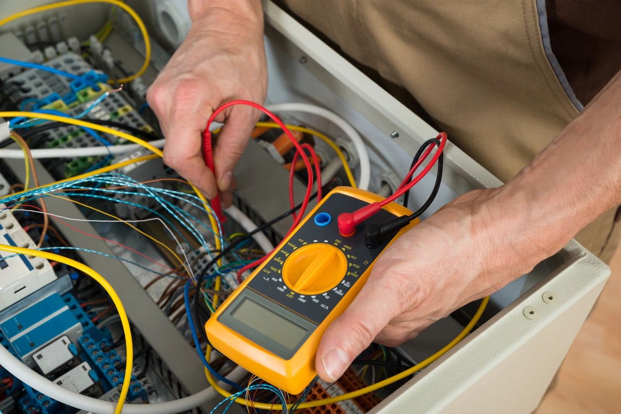 picture of person using a volt meter on a switch